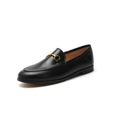 Women with horseshoe buckles and loafers wearing flat bottomed small leather shoes